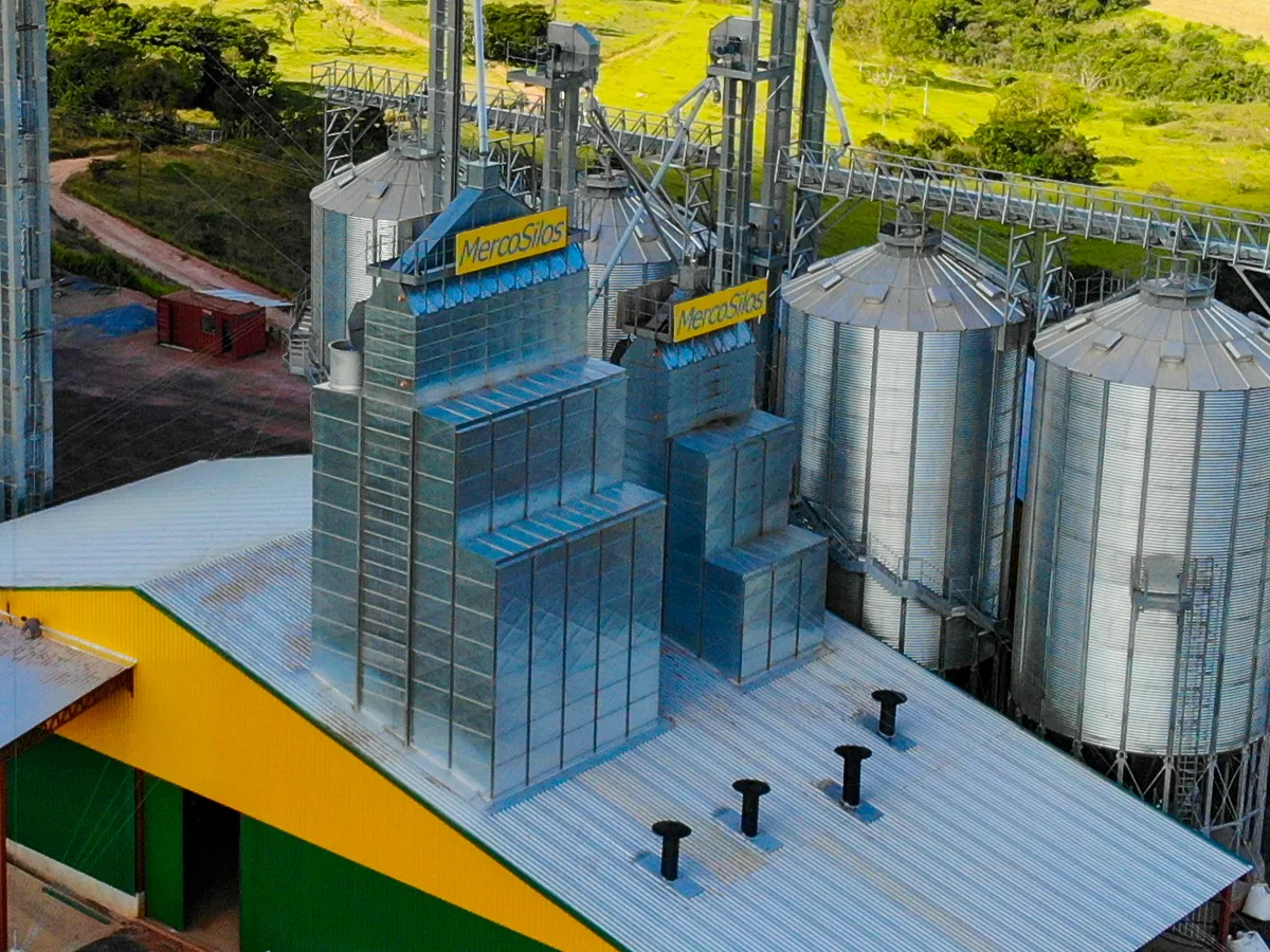 Secador de graos MercoSilos ao entardecer, com identificacao da marca em amarelo na estrutura