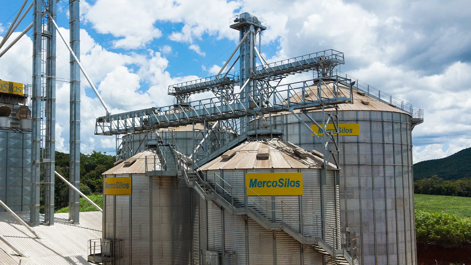 Correia transportadora MercoSilos elevada sobre silos metalicos, com passarela de manutencao ao longo do percurso